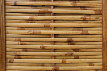 Dry horizontal yellow bamboo wallpaper. Exterior home decoration in Asian country, Japanese, Chinese. Nature construction material. Background and surface, wallpaper concept.