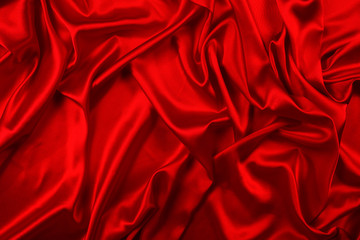 Red silk or satin luxury fabric texture can use as abstract background. Top view.