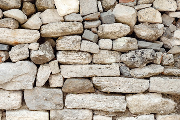 wall made of different stones, not bonded to each other. Texture.