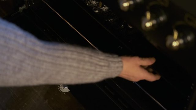 close-up of an elderly woman pulls out Christmas cookies from the oven