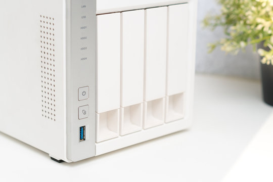 Closeup, Modern and minimal white 4 bays NAS storage server as cloud service for small business and personal use for information and data protection, security, availability and accessibility.