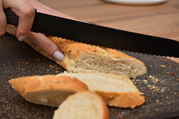 French Baguette on cut board. Fresh bread on the kitchen table. The healthy eating and traditional bakery concept.