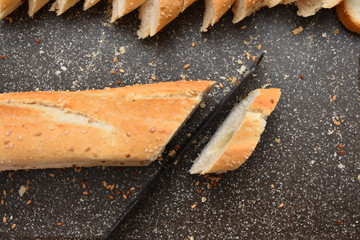 French Baguette on cut board. Fresh bread on the kitchen table. The healthy eating and traditional bakery concept.
