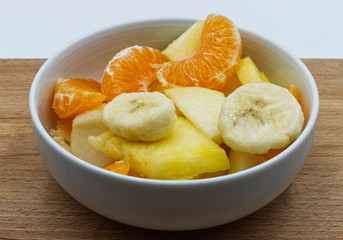Healthy fresh fruit salad on wooden table.