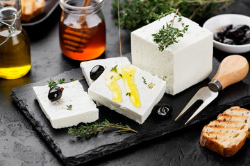 Sliced Feta cheese with herbs and olive oil.
