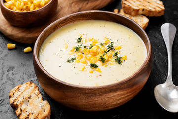 Delicious creamy sweetcorn soup served with toast and corn grains. - obrazy, fototapety, plakaty