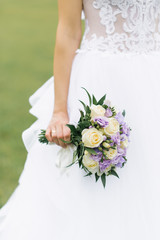 Delicate sophisticated wedding bouquet in the hand of the bride