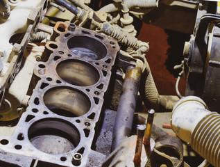 The cylinder block of the four-cylinder engine. Disassembled motor vehicle for repair. Parts in engine oil. Car engine repair in the service