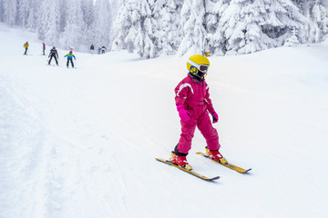 Child skiing in mountains during winter vacation