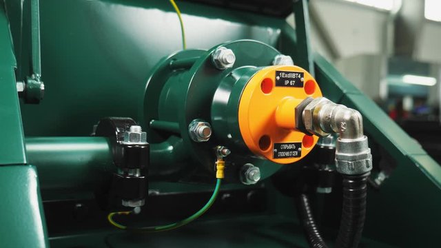 young man connects pipe units assembling modern compressor