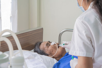 Patients in bed and nurses are preparing to suck up the airways and lungs in the  old aged patients.