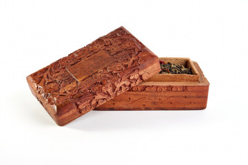 Wooden carved casket with tea on a white background