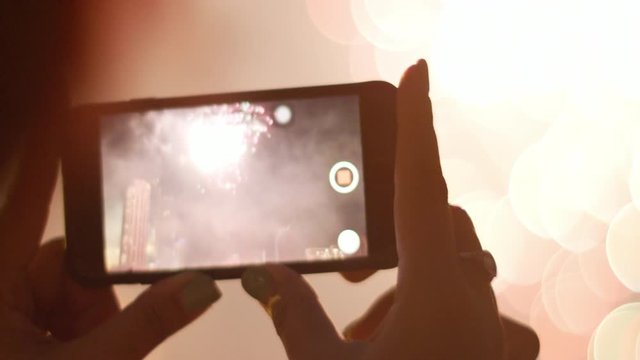 Woman Filming and taking pictures of Fireworks