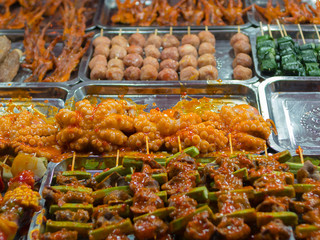 Street food close up in Vietnam, Asia. Delicious food stall selling sticks of grilled meat curry fish vegetables to tourists. Asian cuisine, tasty food, healthy lifestyle.