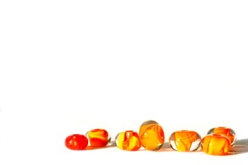 Beautiful colorful cheerful background made of handmade lampwork beads with flames inside. Beads are s isolated on white background, situated bottom right. Suitable for text insert.