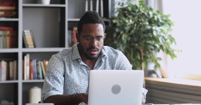 Shocked frustrated african man feel stressed look at computer
