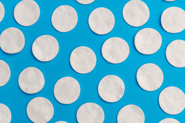 Background by cotton pads on blue. Top view.