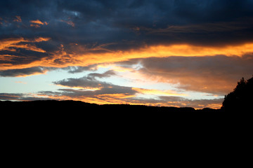 Scenic sunset behind some mountain peaks and hills