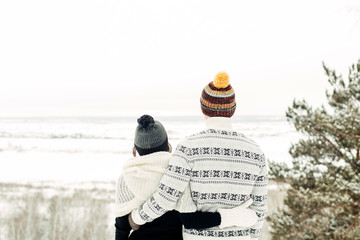 Young couple hugged in winter clothes, rear view