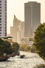 Transport boat on a small canal at sunset in Bangkok, Thailand