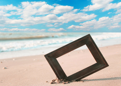 Photo frame on sand beach with blue cloud