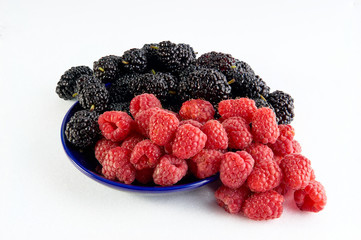 Raspberry and mulberry berries close up on a white background