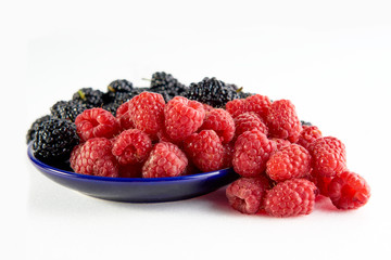 Raspberry and mulberry berries close up on a white background