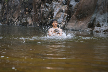 Fototapeta na wymiar Dad and son swimming in waterfall