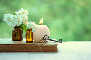 jasmine flowers, vintage key and candle. beautiful scene with candle, white flowers, key, old book....