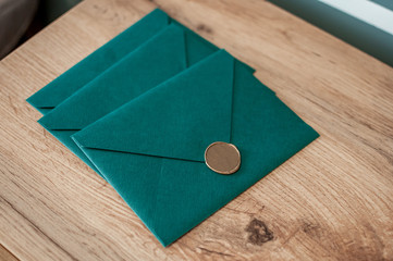Three green letters with wax seal on the wooden table