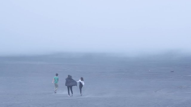 Mother and children running on the sea of sand