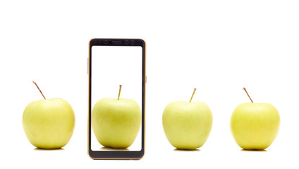 Smartphone with green apple on the screen beside natural apples