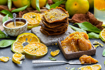 Stacked delicious raw pancakes with dehydrated tangerine and raw jam on top. Tabletop scene with vegan food. Tangerines.