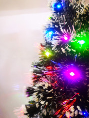Obraz na płótnie Canvas Christmas tree decorated with glittering toys shines beautifully with colorful lights