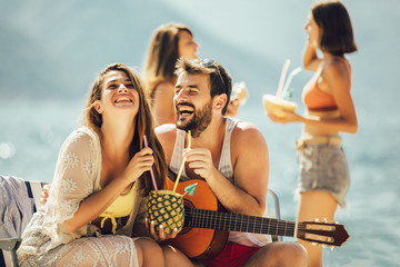 Beach party. Summer time. Young couples on vacation enjoying in a good mood on the beach.