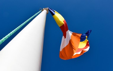 Waving colorful Buddhist Flag in blue sky background
