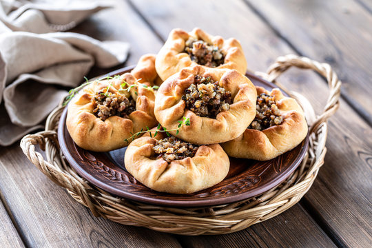 Group of individual pies with meat and potato - vak balish. Tatar traditional pies. Wooden background