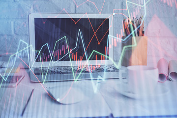 Stock market graph on background with desk and personal computer. Double exposure. Concept of financial analysis.