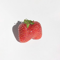 Red strawberry on gray background close-up isolated.