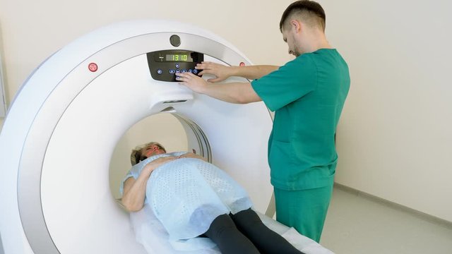 Modern equipment in hospital. Female elderly patient is on medical examination on magnetic resonance imaging or computed tomography scan. 4K