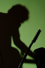 Shadow of the musician on green wall in music club