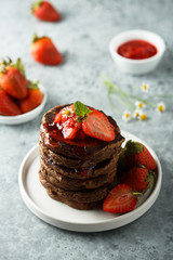 Homemade chocolate pancakes with strawberry sauce