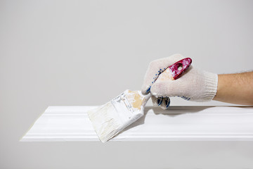 Painting the skirting Board with a white paint brush