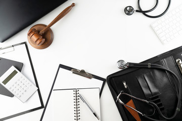 Medical law concept. Gavel, notebook and stethoscope on the white table. Place for text.