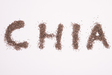 Semillas de chía formando la palabra "chia" sobre fondo blanco.