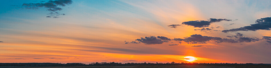 Sunset Sunrise Over Field Or Meadow. Bright Dramatic Sky And Dark Ground. Countryside Landscape Under Scenic Colorful Sky At Sunset Dawn Sunrise. Skyline, Horizon