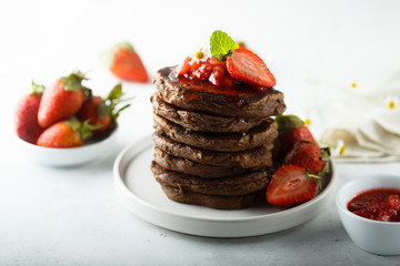Homemade chocolate pancakes with strawberry sauce