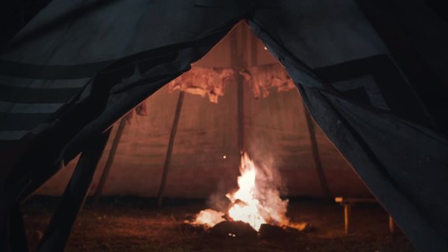 Close up of a indian tent, teepee at night with moonlight and CampFire inside