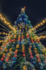 Kremenchuk / Ukraine - December 30 2019: Festive Christmas tree and people celebrating having fun at the Christmas market in the city of Kremenchug, Ukraine
