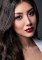 Obraz premium Studio portrait of beautiful young woman. Close-up of pretty girl against gray background